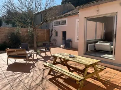 a patio with a picnic table and a bench at Maison la Soleiade in Carcassonne