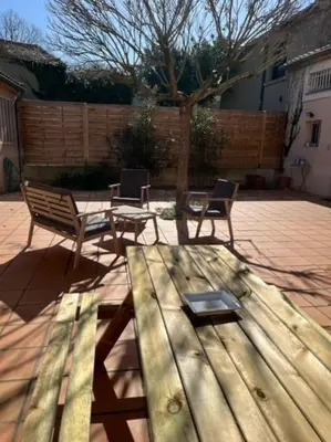 a wooden picnic table and chairs on a patio at Maison la Soleiade in Carcassonne