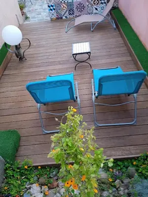 two chairs and a table on a wooden deck at Casa Vignes & Soleil in Puisserguier