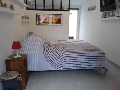 a bedroom with a large bed with a table and a lamp at Casa Vignes & Soleil in Puisserguier