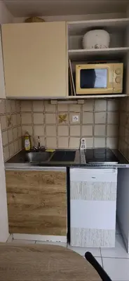 a small kitchen with a sink and a microwave at LOCATION STUDIO EN BORD DE PLAGE A GRUISSAN in Gruissan