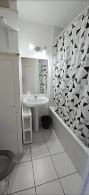 a white bathroom with a sink and a mirror at LOCATION STUDIO EN BORD DE PLAGE A GRUISSAN in Gruissan