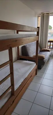 two bunk beds in a room with a window at LOCATION STUDIO EN BORD DE PLAGE A GRUISSAN in Gruissan