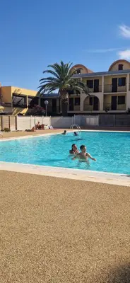 a couple of people swimming in a swimming pool at LOCATION STUDIO EN BORD DE PLAGE A GRUISSAN in Gruissan