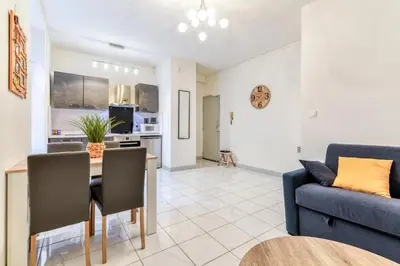 a living room with a table and a blue couch at Le Jacques - Proche centre - RDC - Netflix in Carcassonne