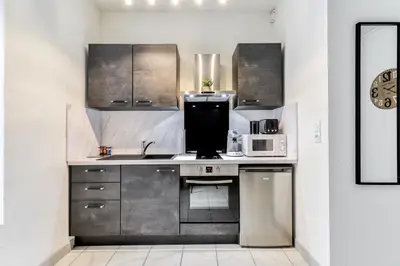 a kitchen with stainless steel cabinets and a microwave at Le Jacques - Proche centre - RDC - Netflix in Carcassonne