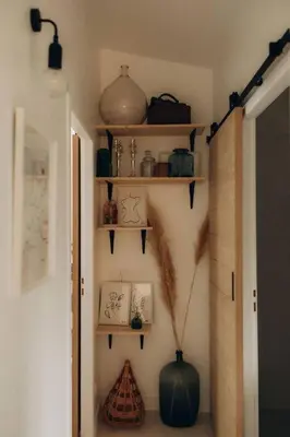 a hallway with shelves and a vase on the wall at Gîtes Chaleureux écoresponsable in Montesquieu-Lauragais