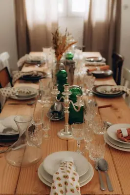 a long wooden table with plates and glasses on it at Gîtes Chaleureux écoresponsable in Montesquieu-Lauragais
