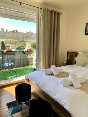 two beds in a room with a large window at Maison face à la cité in Carcassonne
