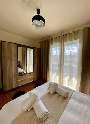 a bedroom with a white bed with towels on it at Maison face à la cité in Carcassonne
