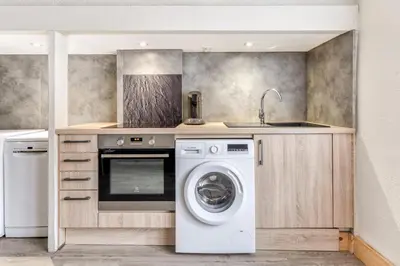 a kitchen with a washing machine and a sink at L'Arche de la Cité - Netflix - Disney - Clim in Carcassonne