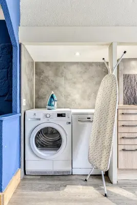a washing machine and a chair in a room at L'Arche de la Cité - Netflix - Disney - Clim in Carcassonne