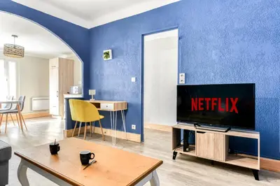 a living room with a tv and a blue wall at L'Arche de la Cité - Netflix - Disney - Clim in Carcassonne