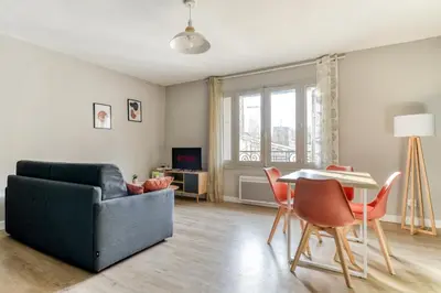 a living room with a couch and a table and chairs at L'Émeraude de la Cité - Netflix - Clim - Proche Cité in Carcassonne