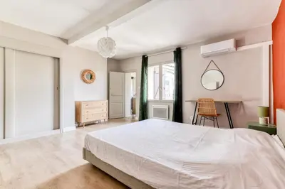 a bedroom with a large white bed and a desk at L'Émeraude de la Cité - Netflix - Clim - Proche Cité in Carcassonne