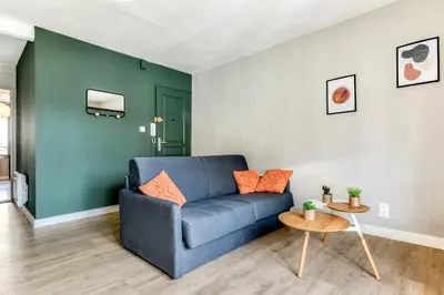 a living room with a blue couch and a table at L'Émeraude de la Cité - Netflix - Clim - Proche Cité in Carcassonne