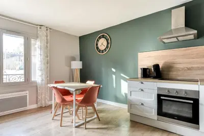 a kitchen with a table and chairs in a room at L'Émeraude de la Cité - Netflix - Clim - Proche Cité in Carcassonne