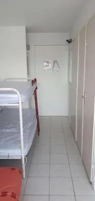 a small room with a bed and a white floor at Gruissan studio aux Amarines au bord de la plage du Grazel in Gruissan