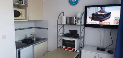 a small kitchen with a tv and a kitchen with alevision at Gruissan studio aux Amarines au bord de la plage du Grazel in Gruissan