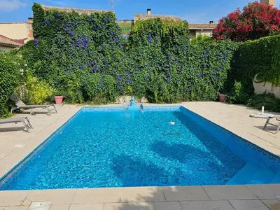 a swimming pool with blue water in a yard at OCC34 - Capestang - Villa Quinlan in Capestang