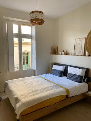 a bedroom with a large bed and a window at Coural’ Home in Narbonne