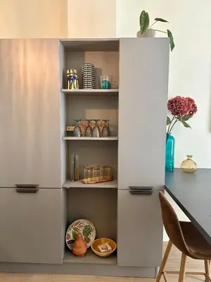 a white bookcase in a kitchen with a table at Coural’ Home in Narbonne