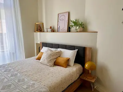 a bedroom with a bed with pillows and a shelf at Coural’ Home in Narbonne