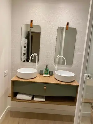 a bathroom with two sinks and two mirrors at Coural’ Home in Narbonne