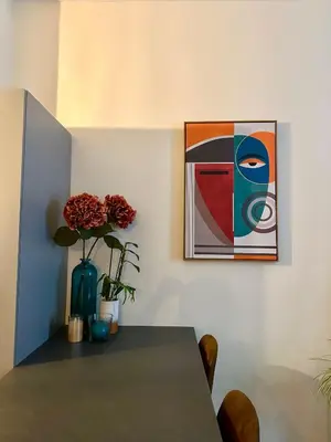 a table with a vase of flowers and a painting at Coural’ Home in Narbonne