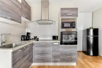 a kitchen with a sink and a microwave at Le Soleil du Lac - Parking Privatif - Terrasse - Netflix - Clim in Carcassonne