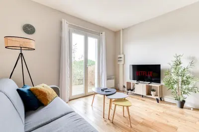 a living room with a couch and a tv and a table at Le Soleil du Lac - Parking Privatif - Terrasse - Netflix - Clim in Carcassonne