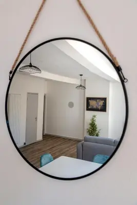 a mirror reflecting a living room with a table and a couch at Ò Grand Carnot/Hyper centre/Proche Gare in Carcassonne