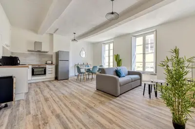 a living room with a couch and a kitchen at Ò Grand Carnot/Hyper centre/Proche Gare in Carcassonne