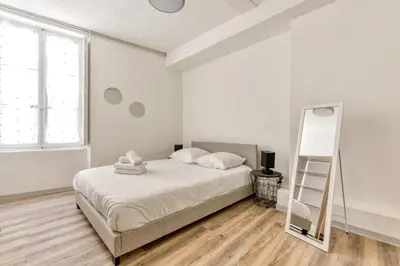 a white bedroom with a bed and a mirror at Ò Grand Carnot/Hyper centre/Proche Gare in Carcassonne