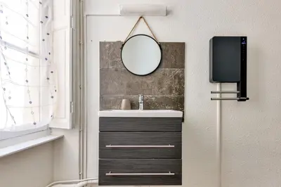 a bathroom with a sink and a mirror and a tv at Ò Grand Carnot/Hyper centre/Proche Gare in Carcassonne