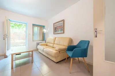 a living room with a couch and a blue chair at Chez papy Charles in Carcassonne