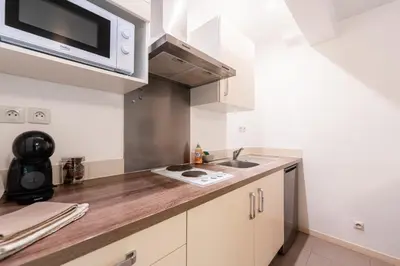 a kitchen with a sink and a microwave at Chez papy Charles in Carcassonne