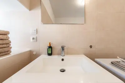 a white bathroom with a tub and a sink at Chez papy Charles in Carcassonne