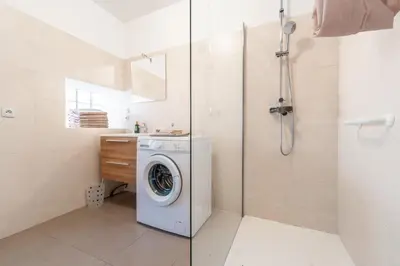 a bathroom with a washing machine and a shower at Chez papy Charles in Carcassonne
