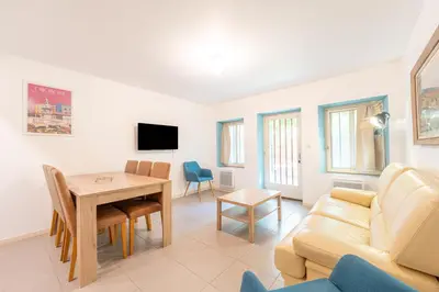 a living room with a table and a couch at Chez papy Charles in Carcassonne
