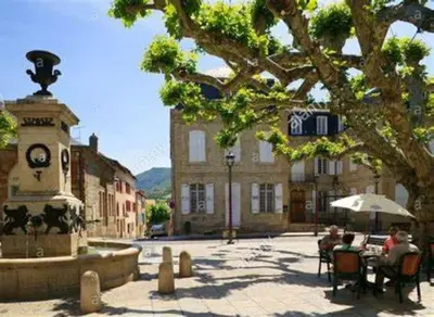a group of people sitting at a table next to a fountain at OCC34 - Capestang - Vigneron in Capestang