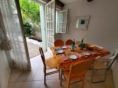 a dining room with a table and chairs and a window at OCC34 - Capestang - Vigneron in Capestang