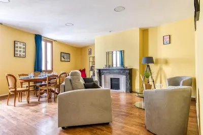 a living room with a table and chairs and a fireplace at Maison du capitole in Narbonne
