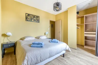 a bedroom with a bed with blue towels on it at Maison du capitole in Narbonne