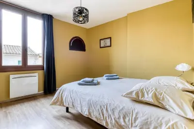 a bedroom with a bed with two towels on it at Maison du capitole in Narbonne