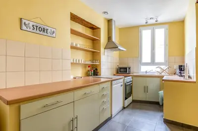a kitchen with yellow walls and wooden counter tops at Maison du capitole in Narbonne