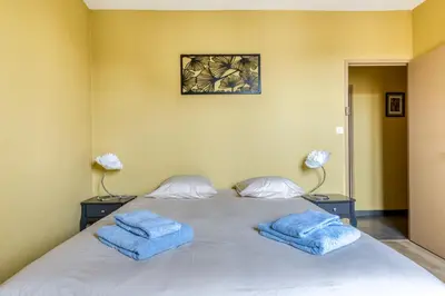 a bedroom with a bed with two blue towels on it at Maison du capitole in Narbonne