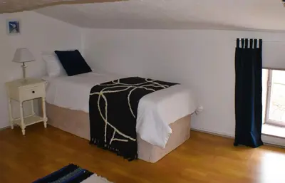 a bedroom with a bed with a black and white blanket at L'Occitania Chambre d'hotes in Puivert