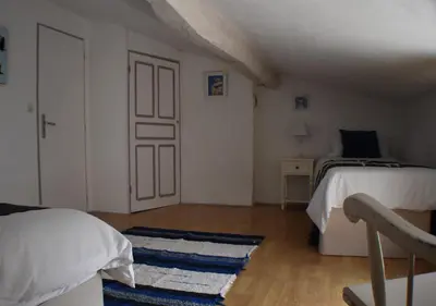 a small bedroom with two beds and a door at L'Occitania Chambre d'hotes in Puivert