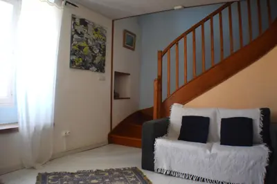 a living room with a chair and a staircase at L'Occitania Chambre d'hotes in Puivert